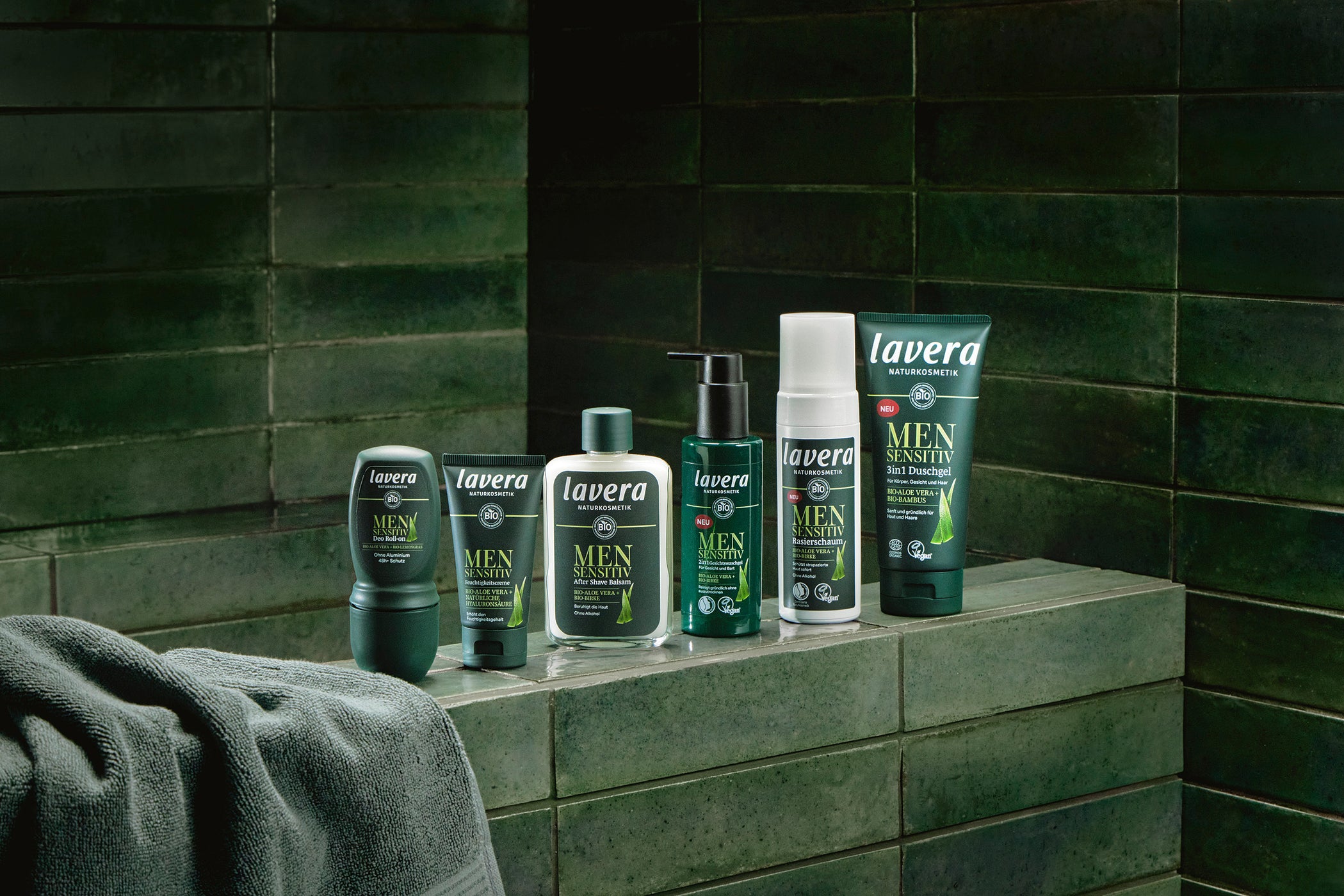 lavera men linea di trattamento affiancati davanti a piastrelle verde scuro
