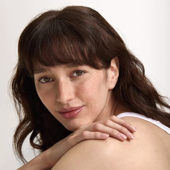 Ritratto di una donna con look naturale e spalla scoperta