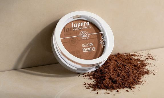 lavera Solid Sun Bronzer aperto con polvere su superficie beige