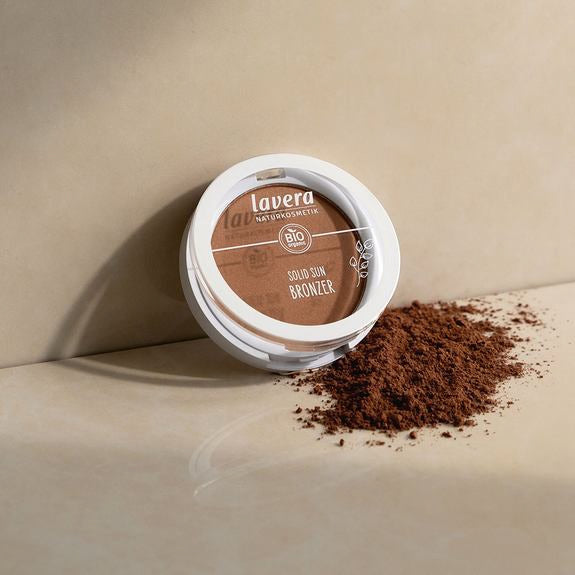 lavera Solid Sun Bronzer aperto con polvere su superficie beige