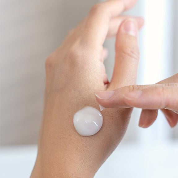 Crema applicata a goccia sul dorso della mano
