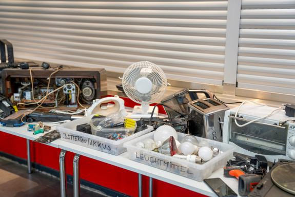 Rifiuti elettronici sul tavolo: vecchi dispositivi, cavi e scatole per batterie e lampadine