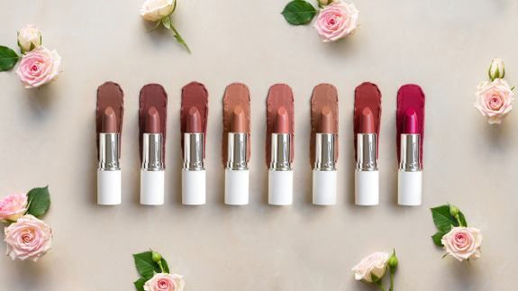 lavera rossetti in vari colori circondati da rose rosa