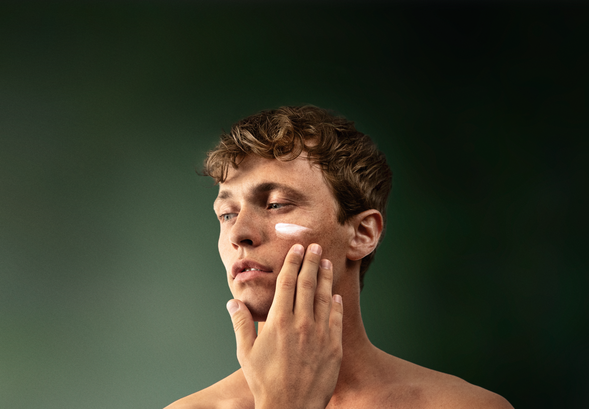 Un uomo applica sul viso la crema idratante lavera Men sensitive.