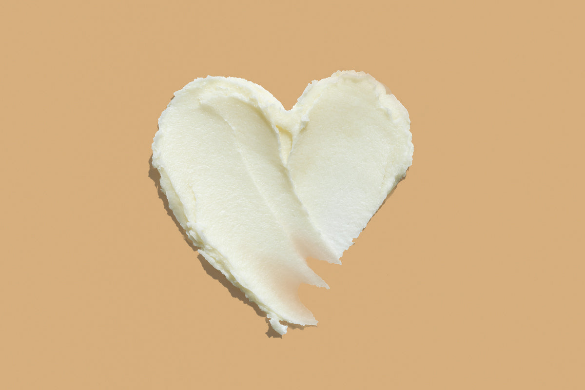 Texture crema a forma di cuore su sfondo arancione chiaro
