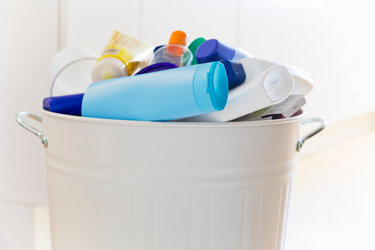 Diversi imballaggi cosmetici in un cestino bianco