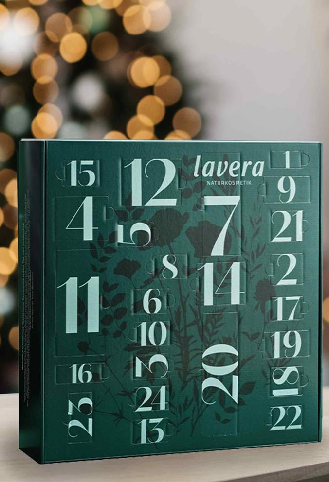 Calendario dell'Avvento lavera verde con numeri, luci festive sullo sfondo