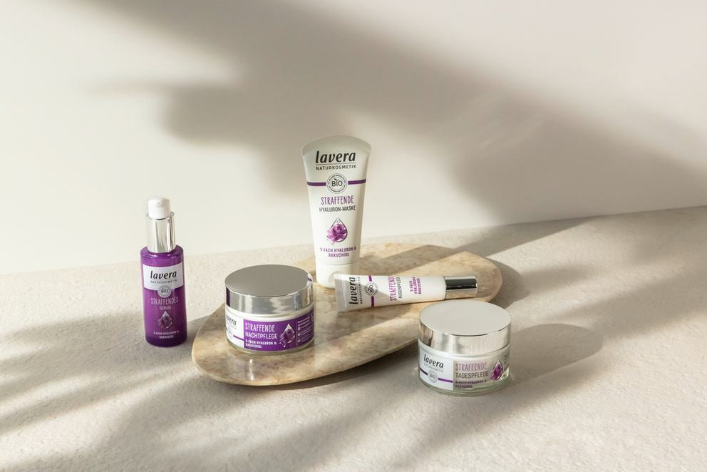 lavera linea di trattamento rassodante con cinque prodotti viola su pietra