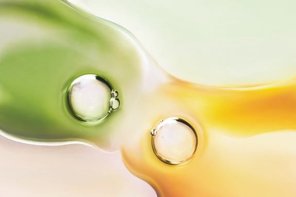 Un liquido giallo e uno verde con rispettive bolle che si fondono