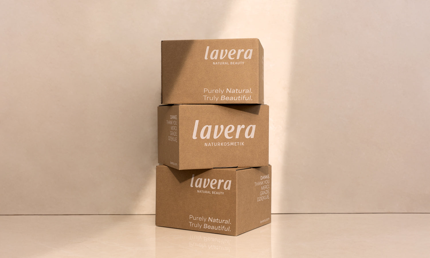 Drei aufeinander gestapelte Versandkartons von lavera
