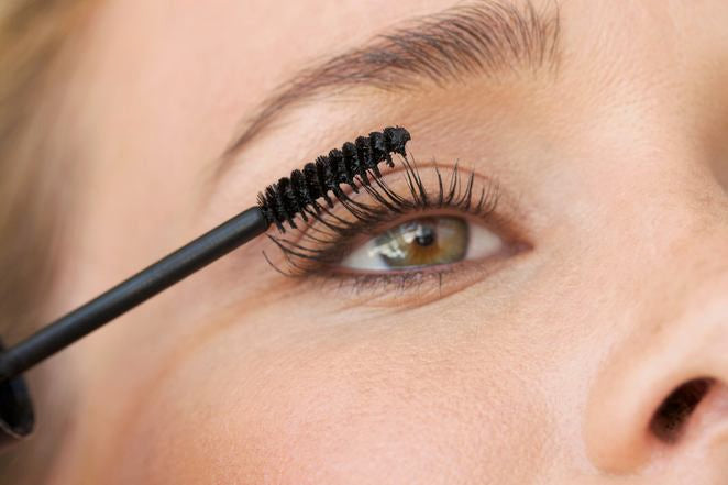 Nahaufnahme: Mascara-Bürste tuscht Wimpern am Auge