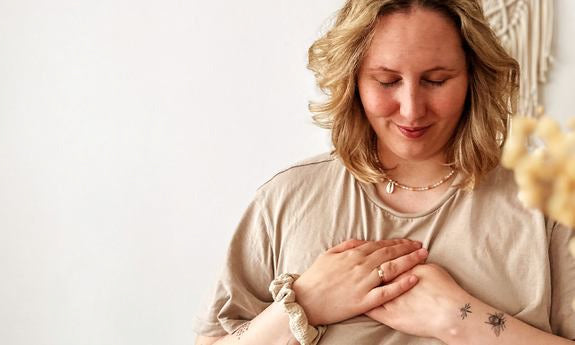 Donna appoggia entrambe le mani sul petto e sorride dolcemente