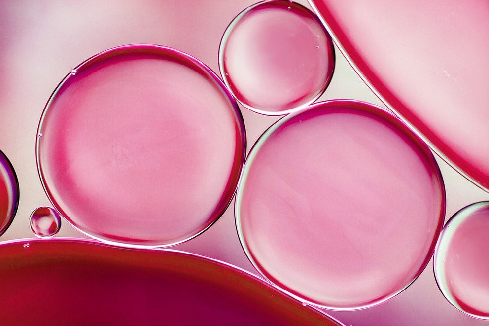 Ripresa macro di bolle d'olio rosa su sfondo chiaro