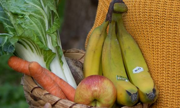 Cestino con banane, mela, carote e bietola