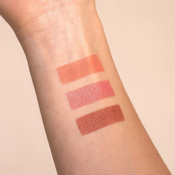 Tre tratti di colore blush in tonalità rosate e marroni su avambraccio