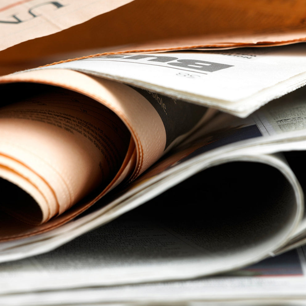 Primo piano di un giornale arrotolato, stampa e notizie