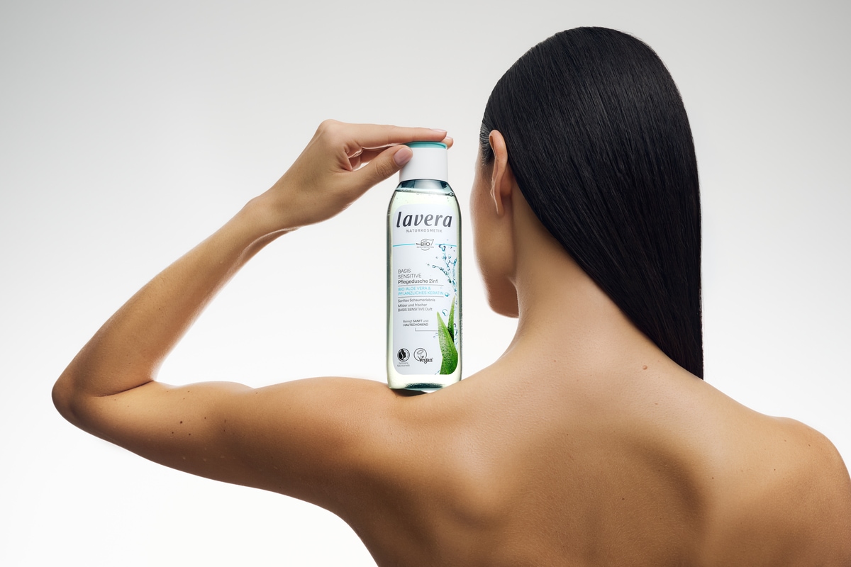 basis sensitive Pflegedusche auf der Schulter einer Frau mit dunklen langen Haaren