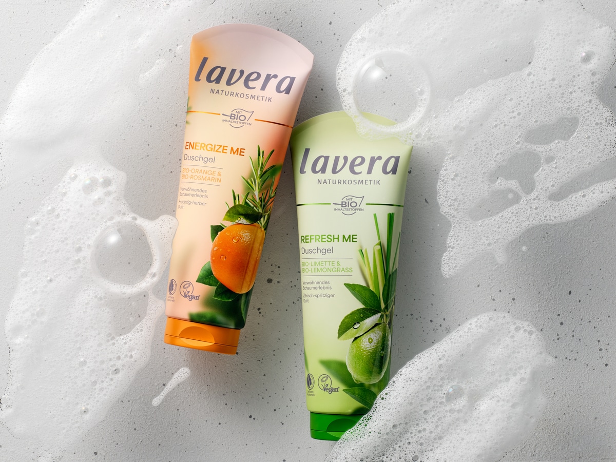 Energize Me und Refresh Duschgel nebeneinander vor schaumigem Hintergrund